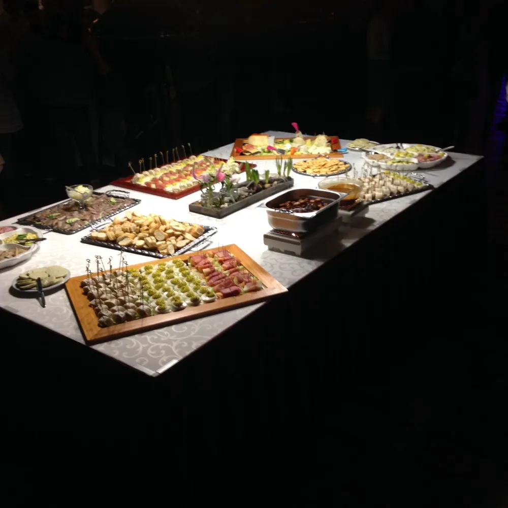 Een rijk gevuld buffet met schalen hapjes, mooi uitgelicht
